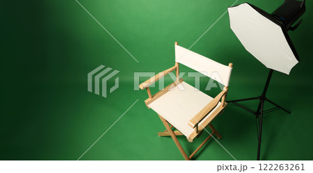 Photo studio with green screen background and stool against lighting equipment. Photo studio with green screen background and stool against lighting equipment. 122263261