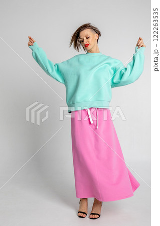 Beautiful girl of model appearance. Portrait of beautiful woman in mint color sweatshirt and pink skirt. Vertical photo. High quality photo 122263535