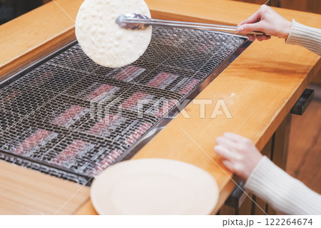 手焼きせんべいを体験する若い女性【撮影協力・新潟米菓 premium SENBEI 田DEN】 122264674