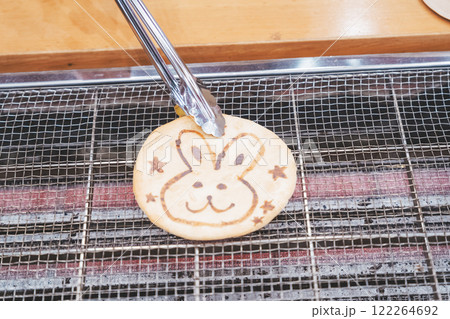 手焼きせんべいを体験する若い女性【撮影協力・新潟米菓 premium SENBEI 田DEN】 122264692