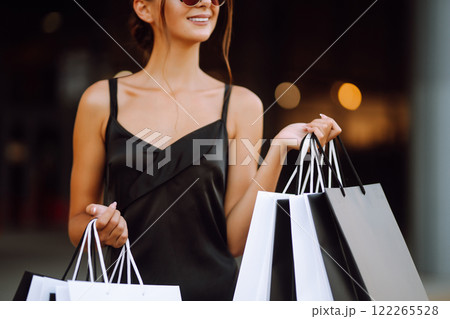 Shopping bags in the hands. Fashion woman with packages after shopping. Black friday, sale. Shopping bags in the hands. Fashion woman with packages after shopping. Black friday, sale. 122265528