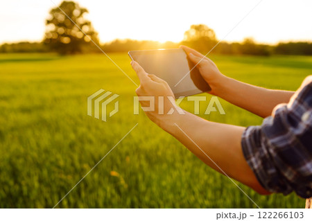 Close-up of the hands of a young farmer with a digital tablet Bountiful harvest. Farm concept. 122266103