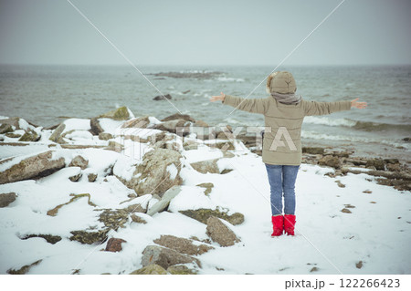 Woman on the shore of a snowy sea. Foggy winter Woman on the shore of a snowy sea. Foggy winter 122266423