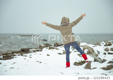 Woman on the shore of a snowy sea. Foggy winter 122266425