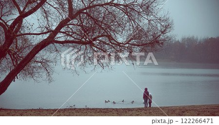 rainy late autumn. woman with child by the lake rainy late autumn. woman with child by the lake 122266471