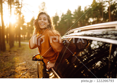 Shot of an attractive woman leaning out of car window while driving. Active lifestyle, travel. Shot of an attractive woman leaning out of car window while driving. Active lifestyle, travel. 122266793