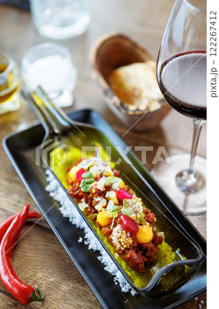 Beef tartare from Black Angus. Egg yolk, pickled cucumber, shallot, pearl onion, coriander and mustard seeds. Delicious healthy Italian food served for lunch in modern gourmet cuisine restaurant Beef tartare from Black Angus. Egg yolk, pickled cucumber, shallot, pearl onion, coriander and mustard seeds. Delicious healthy Italian food served for lunch in modern gourmet cuisine restaurant 122267412