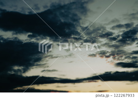 Dusky dark blue yellow sunset sky. Evening cloudscape in twilight. Full sky with last sunshine light and dark blue contrast clouds Majestic sky cloud 122267933