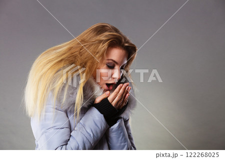 Woman wearing winter warm furry jacket 122268025
