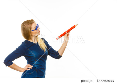 Serious woman holds big pencil in hand Serious woman holds big pencil in hand 122268033