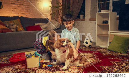 Children, copy and girl sitting on floor and home and playing with dog, pretending to be a vet doctors, putting bandage on pet 122268462