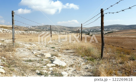 Daylight rural path with barbed wire 122269618