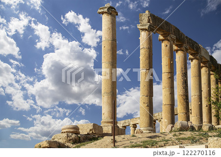 Roman Columns in the Jordanian city of Jerash (Gerasa of Antiquity), capital and largest city of Jerash Governorate, Jordan. Against the background of a beautiful sky with clouds 122270116