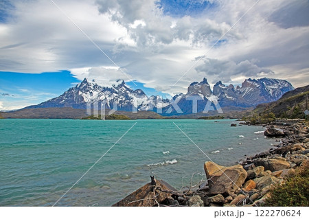 Panoramic view of Lake Pehoe with reflections of dramatic mountains and expansive skies in Torres del Paine Panoramic view of Lake Pehoe with reflections of dramatic mountains and expansive skies in Torres del Paine 122270624