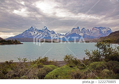 Panoramic view of Lake Pehoe with reflections of dramatic mountains and expansive skies in Torres del Paine Panoramic view of Lake Pehoe with reflections of dramatic mountains and expansive skies in Torres del Paine 122270805