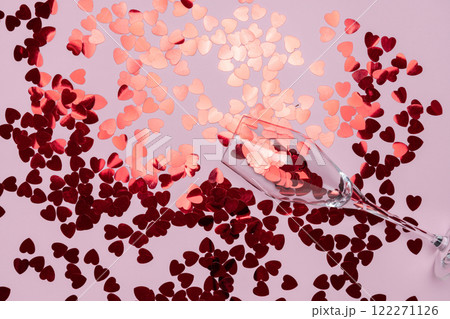 Minimalist Champagne Glass Filled spilling Red Glitter on Pink Backdrop 122271126