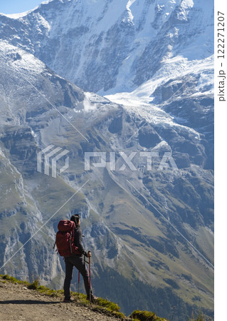 Sporty woman standing in front of snow mountains and enjoying view of Switzerland nature. Wanderlust, sport, beauty in nature. 122271207