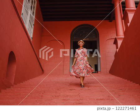 Young woman in ethnic dress and hat exploring the vibrant streets of Malacca, Malaysia. A blend of cultural heritage, colorful architecture, and tropical charm. Perfect travel and lifestyle moments. 122271461