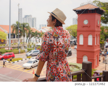 Young woman in ethnic dress and hat exploring the vibrant streets of Malacca, Malaysia. A blend of cultural heritage, colorful architecture, and tropical charm. Perfect travel and lifestyle moments. 122271462