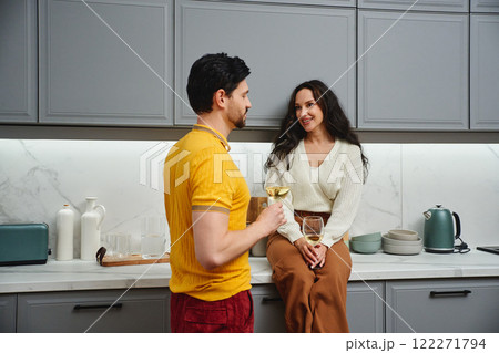 Cozy kitchen conversation with drinks between a couple at home 122271794