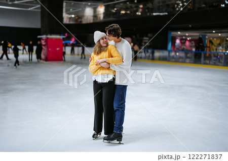 Young couple enjoys ice skating together in a lively indoor rink 122271837