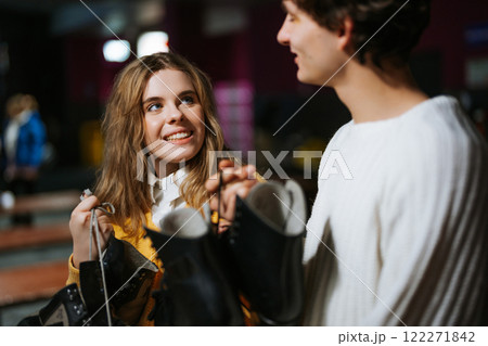 Smiling couple enjoying an evening while shopping for boots in a lively store Smiling couple enjoying an evening while shopping for boots in a lively store 122271842