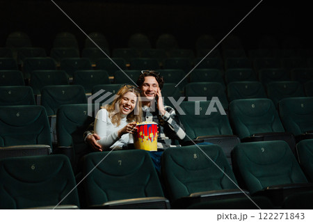 Young couple enjoying a movie together in a nearly empty theater Young couple enjoying a movie together in a nearly empty theater 122271843