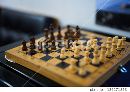 Chess match in progress with wooden pieces on a checkered board Chess match in progress with wooden pieces on a checkered board 122271858