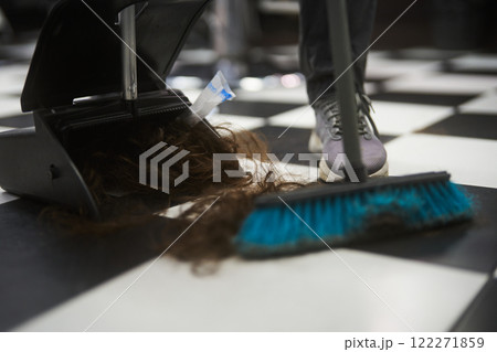 Hair being cleaned up from a black and white checkered floor in a salon Hair being cleaned up from a black and white checkered floor in a salon 122271859