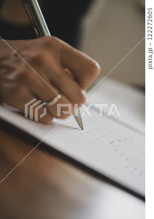 Female hand signing a document Female hand signing a document 122272605