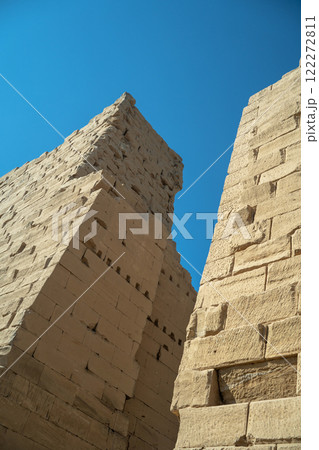 Ancient Egyptian wall in Luxor against blue sky Ancient Egyptian wall in Luxor against blue sky 122272811