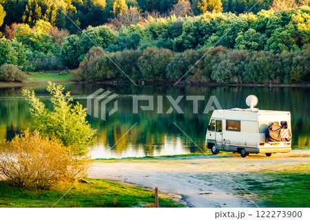 Caravan camping on lake shore with satellite dish on roof Caravan camping on lake shore with satellite dish on roof 122273900