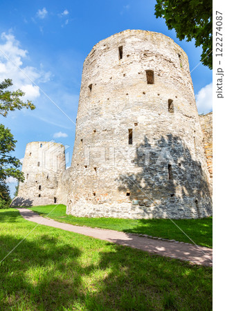 Stone tower of the ancient Izborsk fortress against a blue sky. Izborsk, Pskov region, Russia. Medieval castle on the 14th century Stone tower of the ancient Izborsk fortress against a blue sky. Izborsk, Pskov region, Russia. Medieval castle on the 14th century 122274087