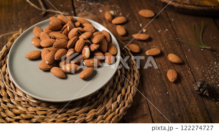 Scattered almonds on a wooden surface Scattered almonds on a wooden surface 122274727