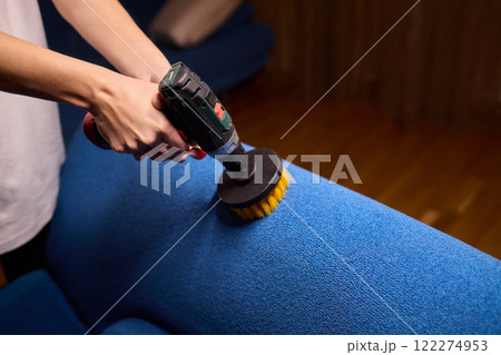 Using a power tool with a brush attachment can effectively clean upholstery furniture and fabrics 122274953