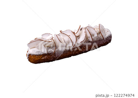 Sweet eclair with custard decorated with coconut slices Sweet eclair with custard decorated with coconut slices 122274974