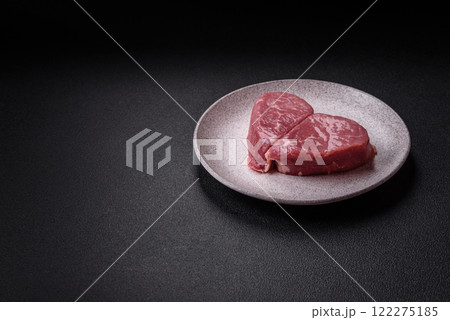 Ribeye steak raw with salt, spices and herbs Ribeye steak raw with salt, spices and herbs 122275185