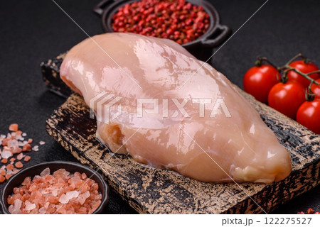 Pieces of raw chicken or turkey fillet with salt, spices and herbs 122275527