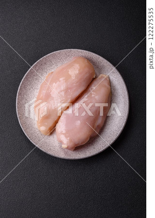 Pieces of raw chicken or turkey fillet with salt, spices and herbs 122275535