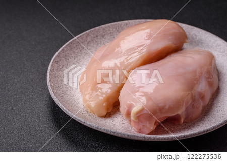Pieces of raw chicken or turkey fillet with salt, spices and herbs 122275536