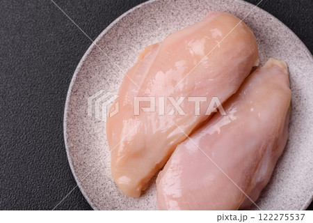 Pieces of raw chicken or turkey fillet with salt, spices and herbs 122275537