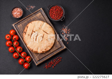 Round flatbread or pita with cheese, herbs, salt and spices 122275627