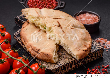 Round flatbread or pita with cheese, herbs, salt and spices 122275635