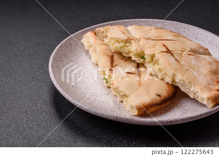 Round flatbread or pita with cheese, herbs, salt and spices Round flatbread or pita with cheese, herbs, salt and spices 122275643