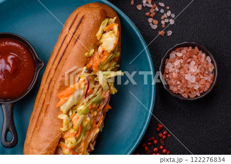 Hotdog with grilled sausage with cabbage, carrots and onions Hotdog with grilled sausage with cabbage, carrots and onions 122276834