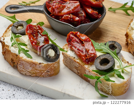 Sandwich with cream cheese and sun-dried tomato slices on white table Sandwich with cream cheese and sun-dried tomato slices on white table 122277916