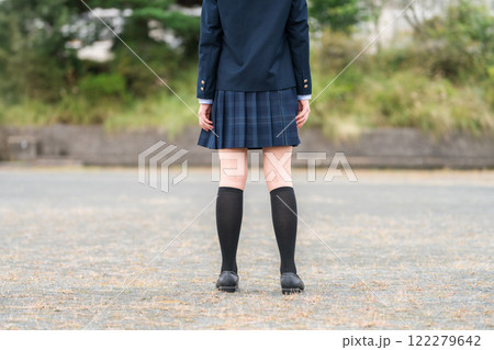 学校の校舎の前に立つ制服姿の中学生・高校生・小学生の後ろ姿 122279642