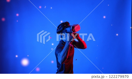 Gamer boxing and punching floating box while wearing VR glasses. Apparatus. Gamer boxing and punching floating box while wearing VR glasses. Apparatus. 122279970