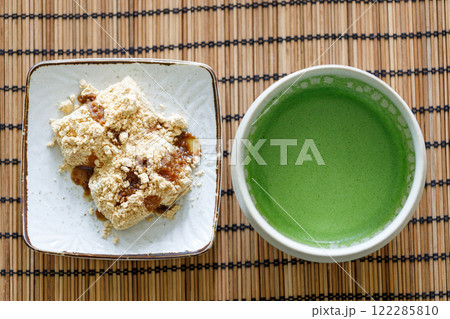 Cup of fresh matcha tea and Warabi mochi, traditional Japanese sweet from bracken starch on wooden table. Cup of fresh matcha tea and Warabi mochi, traditional Japanese sweet from bracken starch on wooden table. 122285810