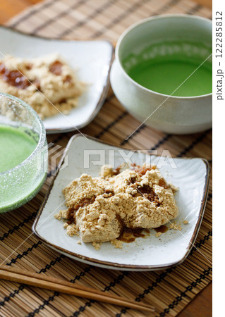 Cup of fresh matcha tea and Warabi mochi, traditional Japanese sweet from bracken starch on wooden table. Cup of fresh matcha tea and Warabi mochi, traditional Japanese sweet from bracken starch on wooden table. 122285812